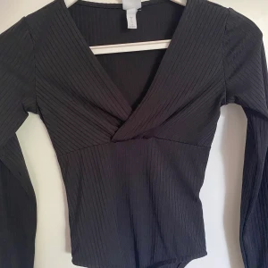 Tröja - Omlott tröja i stretchigt material, storlek XS. Väldigt fin, passar perfekt till fest. Använd 1 gång tidigare.