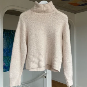 Stickad tröja - Den perfekta stickade tröjan med en krämig ljusbeige färg! Fina muddar och kragen kan man ha både uppvikt och nedvikt. Storlek XS. Köparen står för frakt! OBS!!! Det är flera intresserade så ni får BUDA! Startbud: 130kr + frakt, höjning 10kr per bud. Avslutar imorgon fredag 20/11. Köp direkt för 190+frakt!