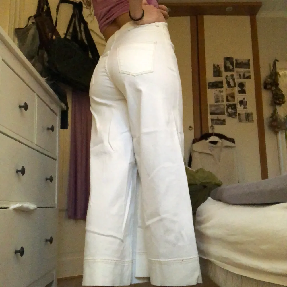 Jättefina vita, vida jeans med ljusbruna sömmar som aldrig använts. De är korta i modellen och går till anklarna 🤍. Jeans & Byxor.