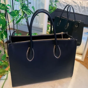 Stor väska - Säljer min rymliga svarta väska med gulddetaljer! Kontakta mig privat för fler bilder eller funderingar💓