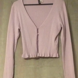 Trendig tröja - En tröja med volanger i slutet på ärmar och nedre del. Stängs med knappar. Rosa/lila                                     Supersnygg med ett linne under 🤤                                   Har använt den 2-4 gånger men det är tyvärr inte min stil längre.                                                                                    Frakt tillkommer, kan tänkas gå ner i pris! 😁  tar helst swish 