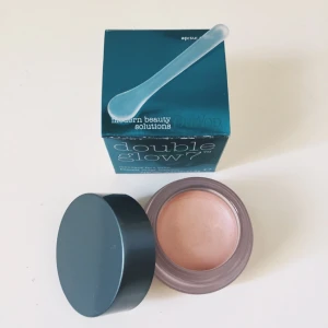  - Helt ny! Ansiktsbalsam/kräm highlighter med många användningsområden. Färg: champagne  "DuWop Doubleglow 7 är ett skimrande ansiktsbalsam med vårdande ingredienser som är förmånliga för din hy (jojobaolja, aloe Vera, Lily extrakt, vitamin A, E och F). Kan användas som primer, under, över eller istället för foundation. Fri från sulfat och parabener, ej testad på djur.