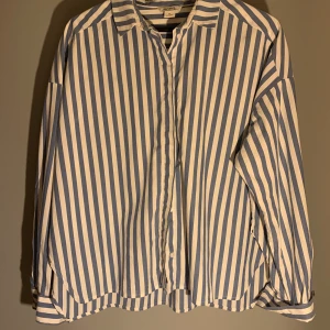 Oversized randig skjorta från Monki stl M.  - Oversized blå och vit randig skjorta från Monki stl M. Skjortan har vita knappar. Använd fåtal gånger, nyskick! Säljer skjortan för 100kr. 
