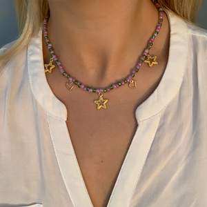 Grönlila pärlhalsband med guldiga stjärnor och små söta guldhjärtan💚💜💫⭐️🤩 halsbandet försluts med lås och tråden är elastisk 