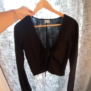 Topp med knyte - Superfin topp i nyskick. Använd 1-2 gånger. Jättefin till high waist. Lätt utsvängda ärmar.  Storlek 36. 