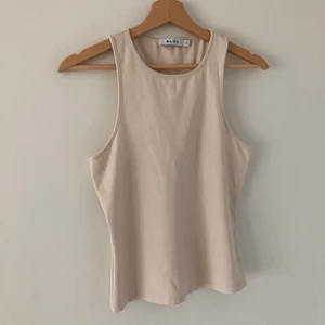 Linne i beige från NAKD  - EJ TILLGÄNGLIG JUST NU NAKD linne med brottarrygg. Använd några få gånger. Frakt betalas av köparen. Skriv gärna om du har några frågor✨