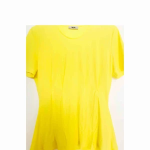 - Oanvänd Acne Studios top i citrongul färg med detaljer som framhäver midja. 