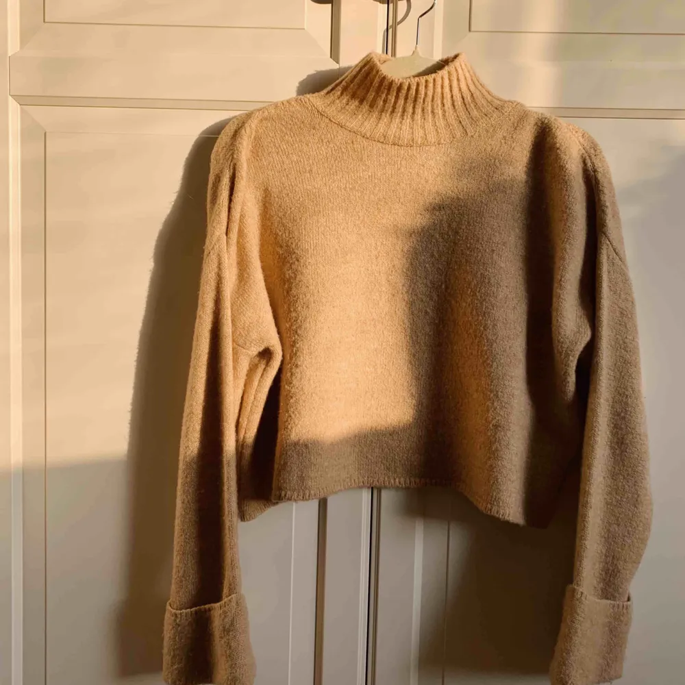 Stickad tröja med vida ärmar och hög krage från GinaTricot. Sand/beige färg - perfekt till hösten! Använd sparsamt. Köparen står för frakt 💛. Stickat.