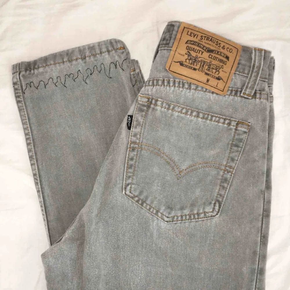säljer dessa superfina grå levis-jeansen med svarta broderade flammor längst ner!! jättebra skick. benlängd (mätt från grenen): 66 cm midjemått: 64 cm frakt på 50 kr tillkommer💫. Jeans & Byxor.