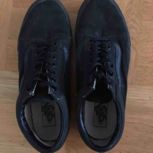  - Helsvarta Vans Old Skool sneakers med brun sula och rött Vans-märke på hälen.  Storlek 42.5 som bilden ovan visar.  Använt ett fåtal gånger och är därför i ett bra skick. Möts upp i Stockholm.