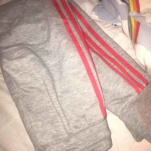  - Adidas mjukisbyxor- gråa med rosa/orange streck Storlek xxs/xs Använda men bra skick Köpare står för frakt!
