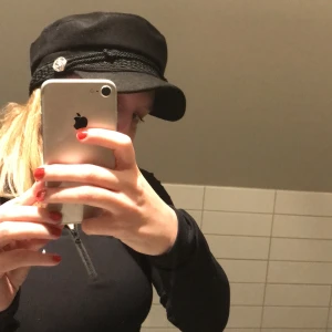 kaptensmössa - kaptensmössa, svart med silver detalj, har lite märken av smink insidan av mössan som inte försvinner, finns i Stockholm 