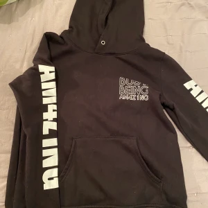 Svart hoodie med vit text - En svart hoodie med lite text över ett av brösten och på ärmarna,, är knappt använd, endast få gånger, pris går att diskutera 💓