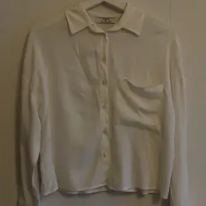 En vit skjorta med en ficka på framsidan