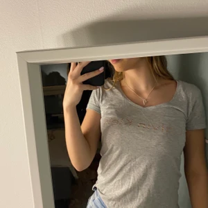 Calvin Klein T-Shirt - Grå Calvin Klein t-shirt med liten v-ringning. Väldigt söt samt skön att ha på sig. Är i storlek XS men passar på mig som är S/M. 