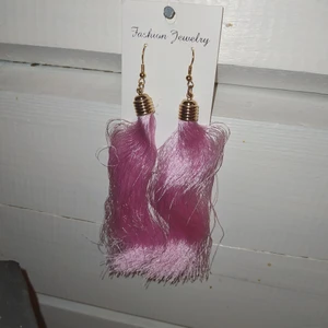 HELT NYA Flamingo rosa tazzles örhängen - Stora rosa tazzles,ej äkta material på själva örhängesdelen bara guldfärgad. OANVÄNDA. frakt tillkommer på 11 kr.