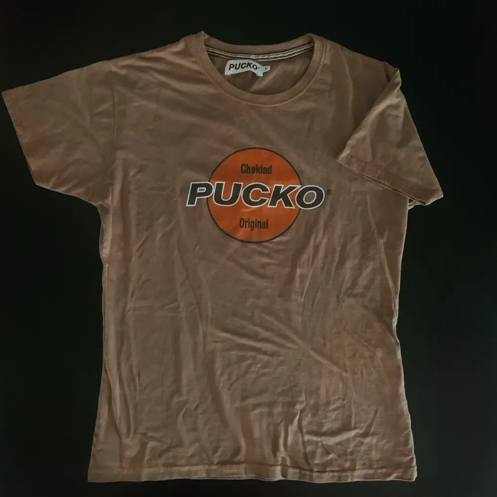Asball t-shirt från PUCKO vintage i beige/brun nyans! Storleken passar en Medium om man vill att den ska sitta tight, för lösare passform skulle jag säga S/xs🍀 (läs min bio innan beställning). T-shirts.