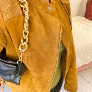 Mango mocka jacka! - Super varm och skön mocka jacka! Finns inte längre på hemsidan för att den är slutsåld! Rundad hals med tryckknappsfäste. Kontrastpanel vid axlarna. Långa ärmar med manschett och blixtlås. Asymmetrisk dragkedja med innerfoder. Funkar både för höst och vår!