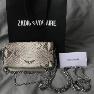 Säljer min väska från Zadig & Voltaire i modellen Rock nano savage clutch bag✨ Se sista bilden för små slitningar på baksidan, annars inga tecken på användning! Buda💞