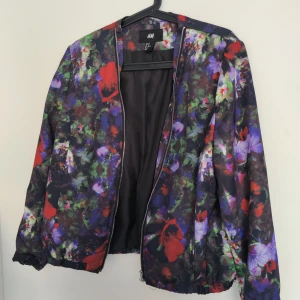 Jacka H&M - Blommig jacka/kofta från H&M. Sparsamt använd, strl 40. Skickar spårbart med PostNord, köparen står för frakten.