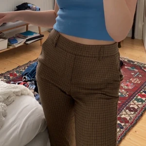 Rutiga byxor - Rutiga (hundtandsmönstrade) kostymbyxor, med en liten slits på innerbenet. Köpte dem här på Plick innan sommaren men inte använt så mycket. Skriv gärna om du vill ha mått/mer bilder osv 🥰  Pris går absolut att diskutera om det är så 
