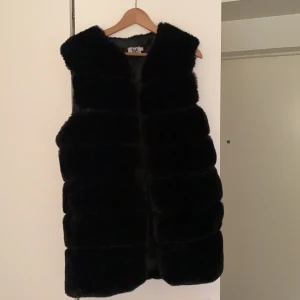 Urban mist väst stl 14 - Väst i svart fuskpäls. Den går över rumpan. 