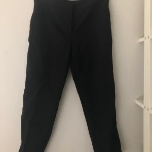 Kostymbyxor från Zara - Svarta kostymbyxor med guldig kant längs benet från Zara. Storlek 38, nyskick. 250kr