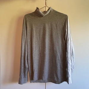 Politröja - Grå basic polotröja från Beyond Retro. Långa armar och ett mjukt material. Halstyget är gjort av ett lite tjockare material som gör att man kan få den att ligga helt platt och rakt eller hursomhelst om man vill. 