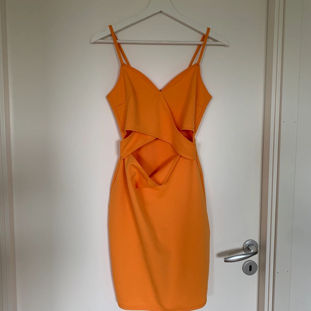 Gul/orange klänning med en liten öppning fram samt på sidorna. Storlek M (Liten i storleken) . Klänningar.