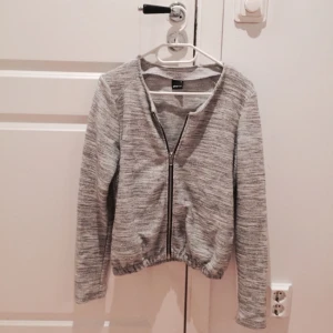 - Grå och lite "skimrig" stickad bomberjacka från Gina Tricot. Använd en gång, i nyskick! Strl M, men passar även mig som har S om man vill ha lite "oversize". Kan skicka fler bilder vid intresse! 