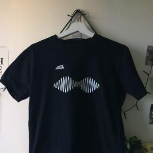 Fin svart t-shirt med ett Arctic Monkeys tryck. Tröjan är ungefär 1 år gammal och använd några gånger. Passar till både killar och tjejer.