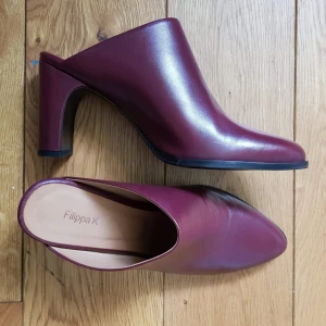  - Helt oanvända högklackar från Filippa K. Färg i lila/röd. Storlek 38, kan även passa 37 utan problem. 