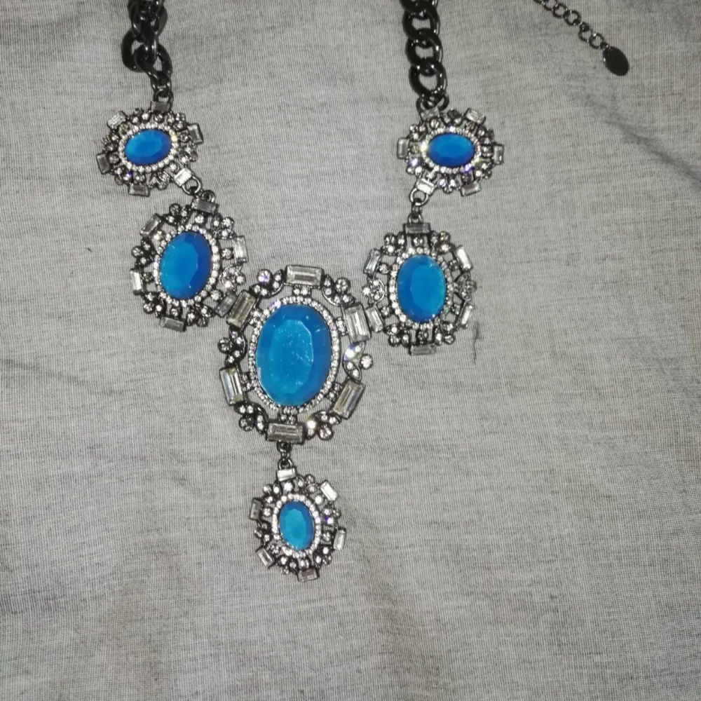 Halsband i kort modell med stora blå stenar . Accessoarer.