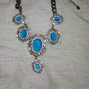 Halsband i kort modell med stora blå stenar 