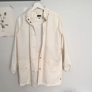  - Krämig vit Levi’s regn- och vindjacka med extra ficka på baksidan. 2:a bilden visar några gråa märken men annars i gott skick. 
