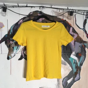  - Riktigt snygg, väldigt gul, t-shirt som också är något genomskinlig. Köpt på Junkyard, men bara provad aldrig använd.   Köparen betalar frakten. 