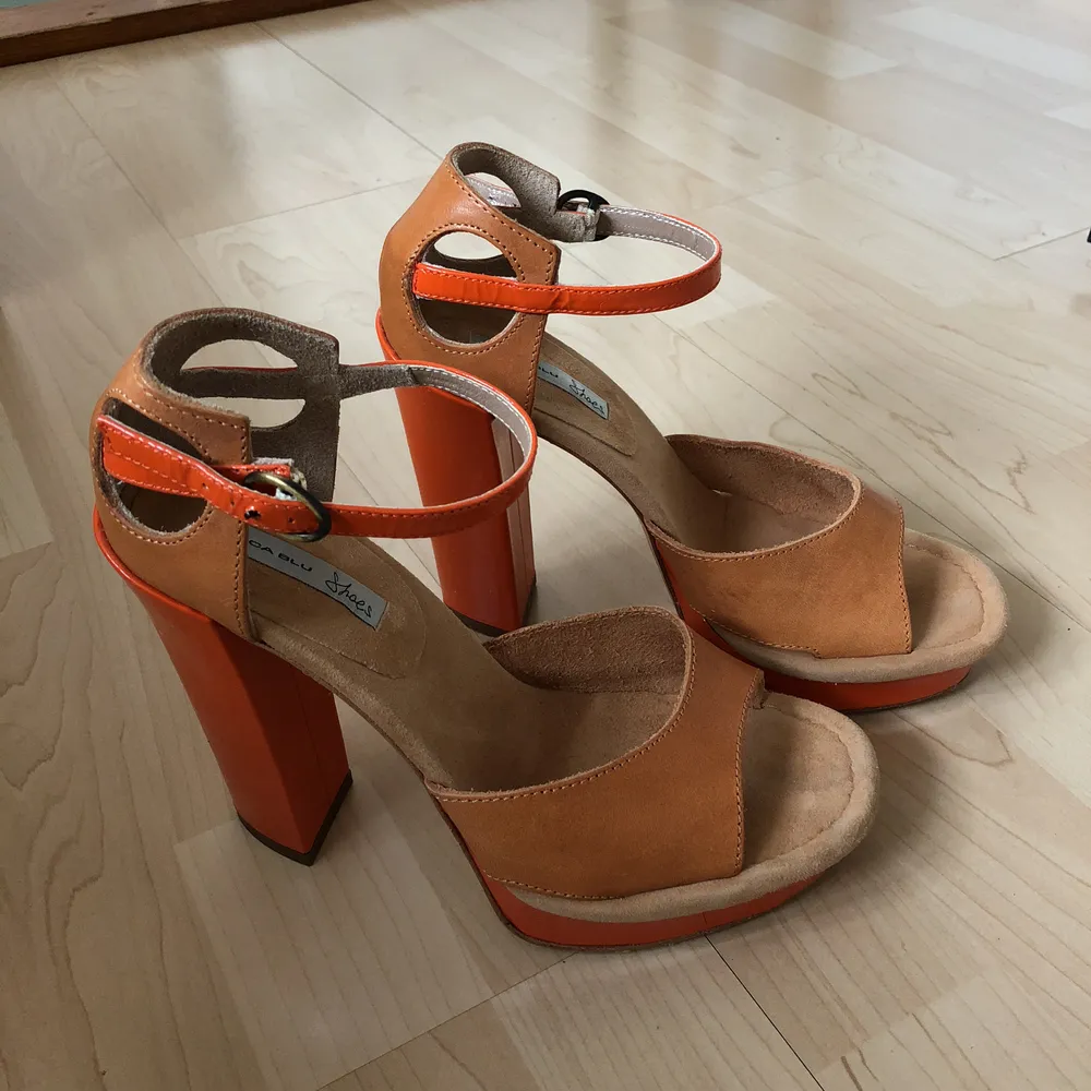 Snygga högklackade skor från Tosca Blu i brunt läder och platåsula i orange. Klackhöjd: 13,5 cm. Knäppning kring vristen. Oanvända, köptes för 1499:- på Nelly. Frakt 29 kr🌿. Skor.
