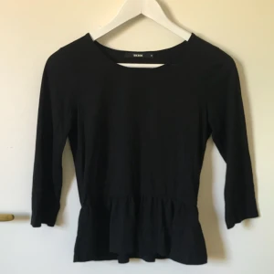  - Trekvartsärmad svart tröja med volang nedtill i strl S! 90kr + frakten.