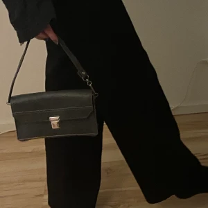 Väska - En söt liten vintage väska. Går ej att reglera bandet, men är fett snygg till outfits! Den har en blå/grå färg. 