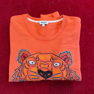 Kenzo tröja - Snygg, klassisk, orange tjocktröja från kenzo! Storlek Large, men jag skulle mer säga att det är mer som en small. 150kr, buda i kommentarerna vid stort intresse.