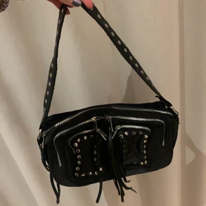 Núnoo bag - En supersnygg svart väska från det populära märket Núnoo🖤 fransar från dragkedjorna och silvriga detaljer på väska och väskband😚. Superbra skick, använd fåtal gånger! Hör av dig om du är intresserad! Nypris runt 700kr, säljer från 199kr☺️☺️