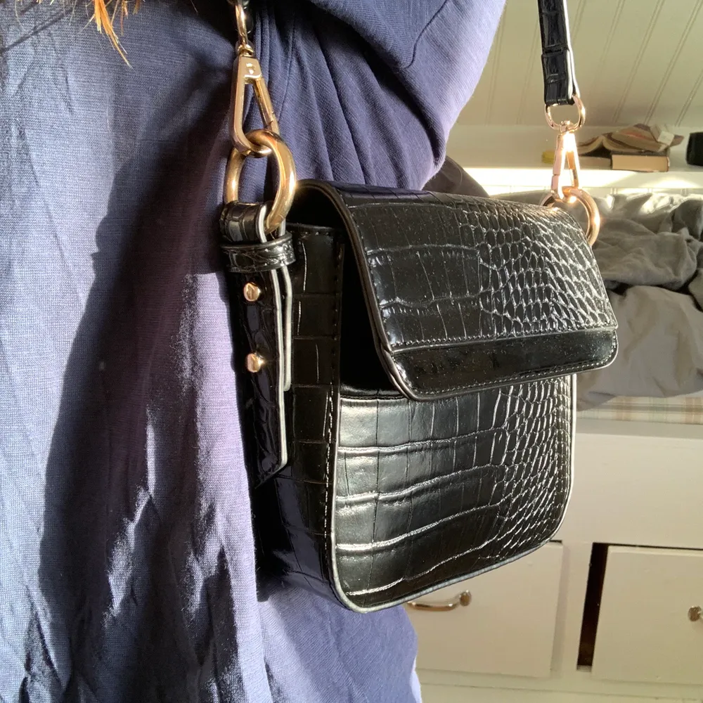 En riktigt fin svart väska i krokodilmönster, säljer på grund av att jag inte använder den, därför är den i nyskick, den är köpt för 350kr men säljer för 90+ frakt (66kr). Om flera är intresserade så blir det budgivning🥰🥰. Väskor.