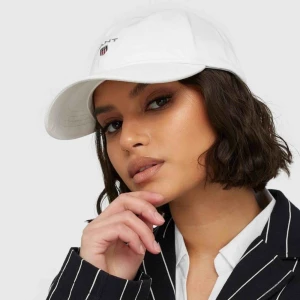  - Vit keps från GANT. Fint skick, knappt använd!  Bild lånad från Nelly.com