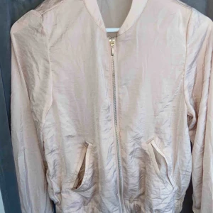  - Rosa tunn jacka med guldiga detaljer och dragkedja, använd några gånger men fortfarande i ett fint skick. Fungerar för dig med S också då den är lite större i storleken.