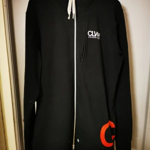 Snowboardhoodie från Colour Wear - Hej!  Jag har använt denna som oversize "ytterjacka" när jag åkt snowboard i Riksgränsen och Alperna.  Unisex  Lång och rak i modellen  Två sidofickor och en bröstficka  Rymlig huva!  Gråsvart i färgen.  Storlek X-Large  55% Bomull 45% Polyester  För er som vill veta om märket WearColour (CLWR) så är det ett svenskt märke med rötter och influenser från skateboard, snowboard, musik & gatukultur. Med andra ord plagg med attityd, som passar både på berget & i stan.  Kläderna skapas helt enkelt med rena enkla linjer & schyssta detaljer och andas skandinavisk design & streetstyle. Kan skickas mot fraktkostnad i förskott! Ha det gott 🍀