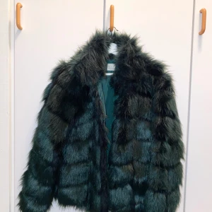  Fake fur jacka  - Grön fake fur jacka i storlek 32 ifrån Nelly.com. Bra skick använd endast ett få tal gånger. 