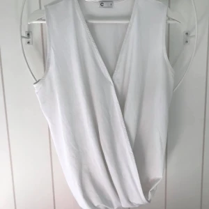 Vit topp, storlek S - Vit topp som går i omlott i fram. 