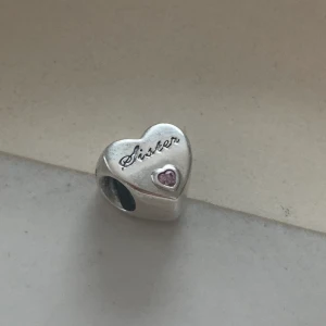 Pandora Berlock ”Sister” med rosa sten  - Ny, ej använd, i silver. Ny pris 399kr, mitt pris 200kr