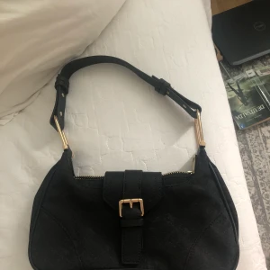 Väska - Säljer denna fina baguette väska för att den tyvärr aldrig kommit till användning, föredrar silver detaljer och därför har jag inte använt denna, den är som ny! Köpte för 349kr på ASOS för något år sedan, så buda gärna från 100kr :) kan mötas upp eller frakta, men köparen står för frakten.