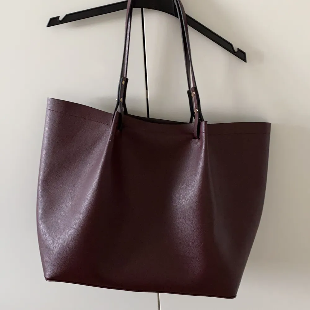Säljer en nästan ny mörkröd shopperväska från H&M. Använd bara ~4 gånger. Väskan är jättefin. Storlek är 36 X 16 X 32 cm. Mötas / frakt kommer . Väskor.